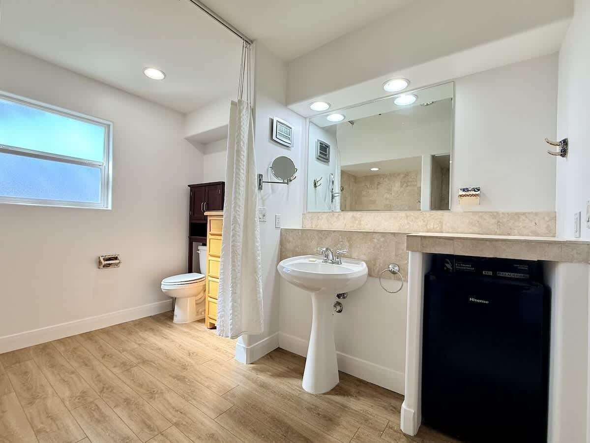 A bathroom with a toilet, sink, and dishwasher.