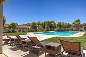 A pool area with lounge chairs, a swimming pool, and a lawn. - Amira Resort #17 | Studio | Near Pools and Pickleball! (Saint George)