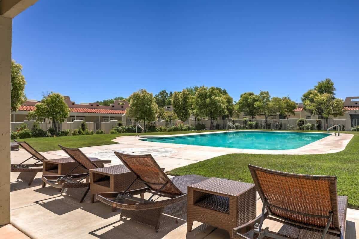 A swimming pool with lounge chairs and a covered patio area.