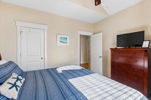 A bedroom with a bed, dresser, and TV. - CB23 - Stella Blue- Spacious 4BR home in Corolla, pet-friendly, with hot tub. (Corolla)