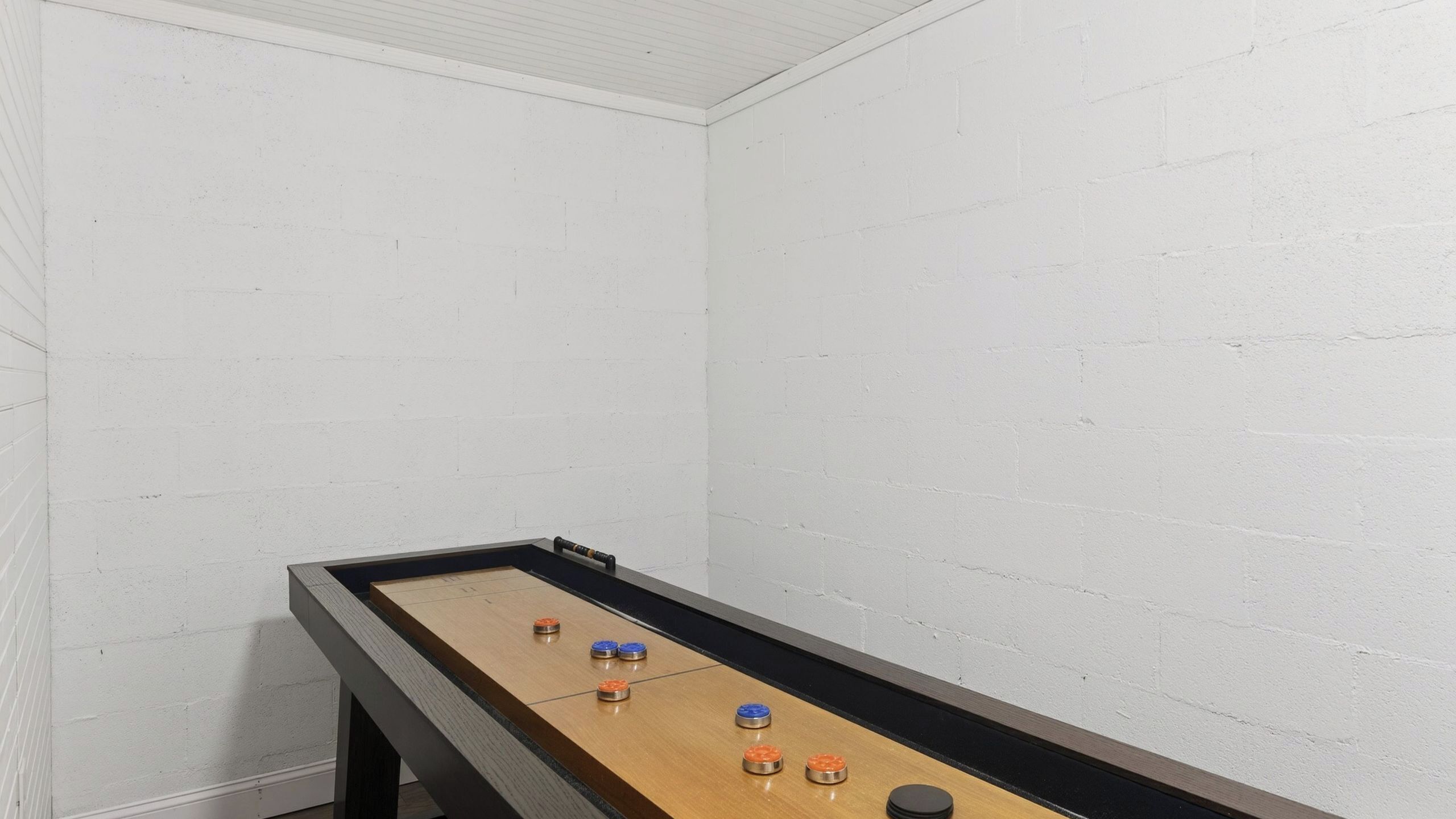 Ein Brettspielaufbau in einem Raum mit weißen Backsteinwänden und schrägverlaufender Decke.