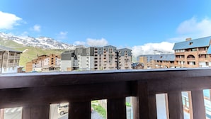 Um hotel com vários andares, varandas e vista para montanhas nevadas.