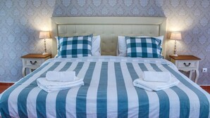 A bed with striped bedding, two bedside tables with lamps, and a patterned wallpaper. - Chalet With Pool Meia Praia Beach, Lagos (Lagos)