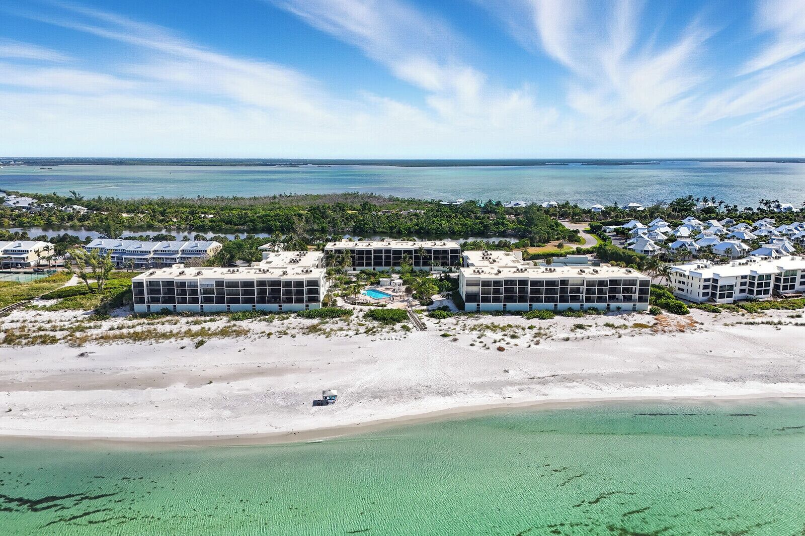 Ein Resort mit mehreren Gebäuden, einem Strand und freiem Blick auf den Ozean.