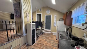 A modern kitchen with a built-in refrigerator, a coffee station, and a dining area with a table and chairs. - Stylish 4BR Loft • Sleeps 8 • Prime Location (Oswego)