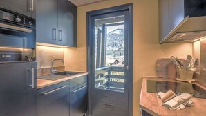 Una cucina moderna con un forno Bosch, un lavello e vista su una montagna innevata.
