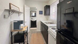Una cocina compacta con cafetera, estufa y refrigerador.