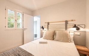 A bedroom with a bed, bedside lamps, a window, and a door. - Luxueuse villa proche plage (Les Portes-en-Ré)