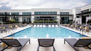 A modern hotel pool area with lounge chairs and a clear view of the pool. - Modern Luxury 1BR Skyline Views + Pool (Atlanta)