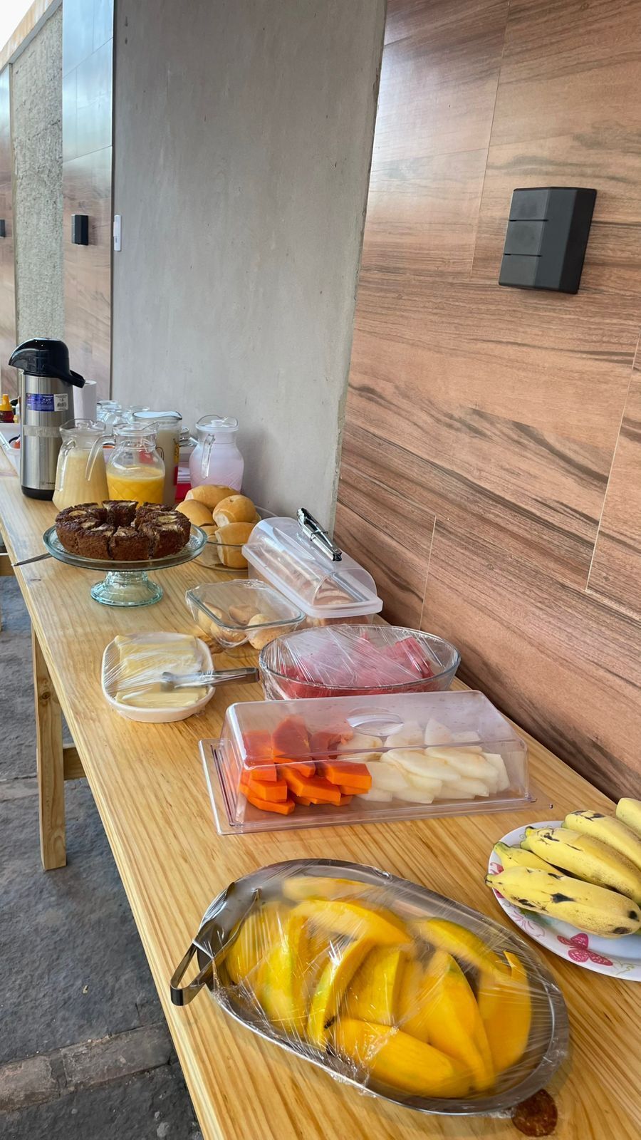 Ein reichhaltiges Frühstücksbuffet mit verschiedenen Speisen und Beilagen auf einem Holztisch.