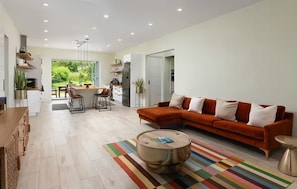 Ein modernes Wohnzimmer mit einer Couch, einem Couchtisch und einem Essbereich mit Stühlen.