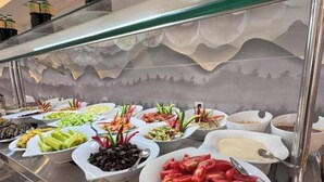 Un bufé con diferentes opciones de comida y una pared decorativa.