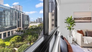 A modern interior with a large window, a sofa, a potted plant, and a cityscape view. - Skyline Pool & Spa Miami (Miami)