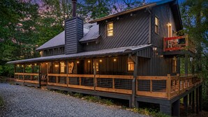 A two-story wooden cabin with a deck and a chimney. - Cabin Sleeps 12: Screened Hot Tub, Arcade, Dogs (Blue Ridge)