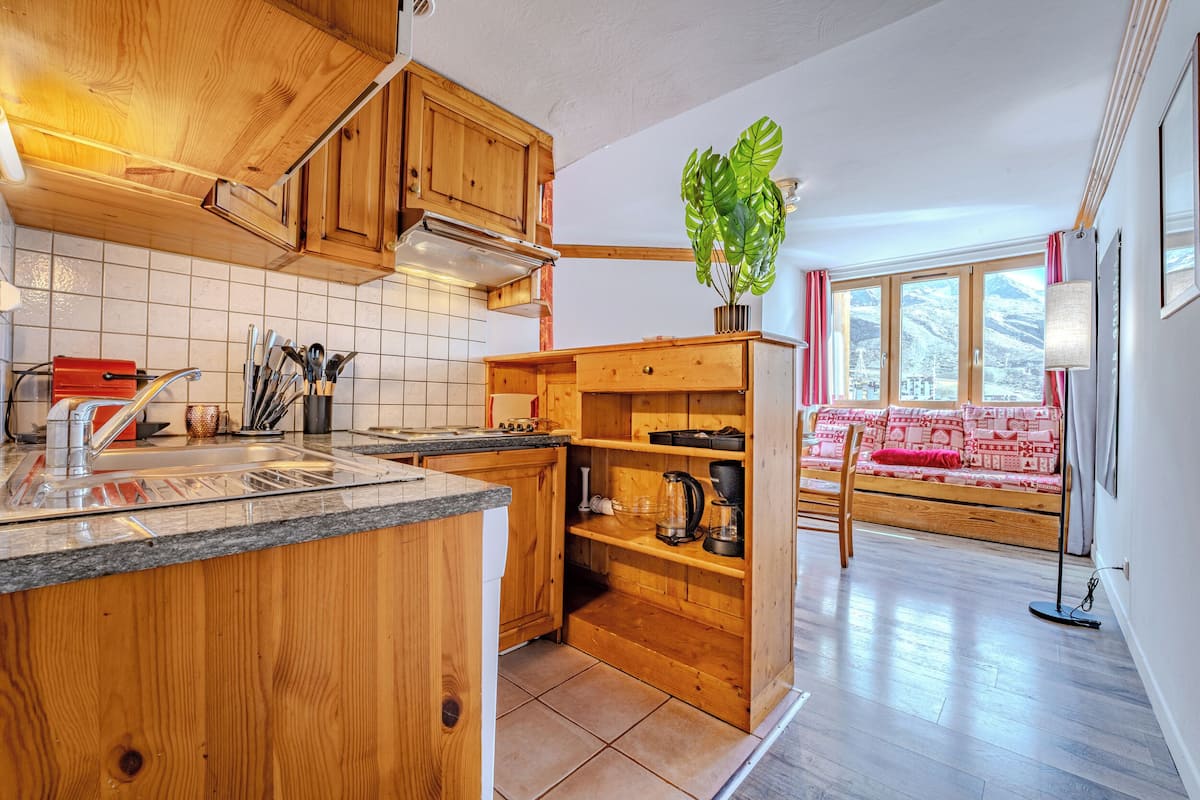 Una cocina con armarios de madera, encimera de granito y una planta.
