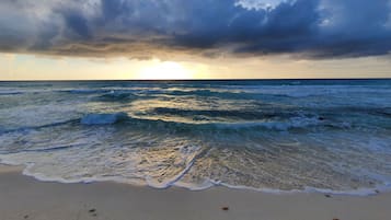 Ein Strand mit Wellen und einem bewölkten Himmel.