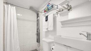 Une salle de bain moderne équipée d’une douche, de toilettes et d’un lavabo.