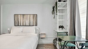 Une chambre à coucher comprenant un lit, une table de chevet, une étagère murale avec des plantes, une petite table et une chaise.