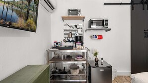 Une petite cuisine équipée d’un four à micro-ondes, d’un grille-pain et d’un petit réfrigérateur.