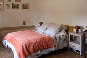 Ein Schlafzimmer mit einem Bett, Kissen, einem Nachttisch und einer Lampe.