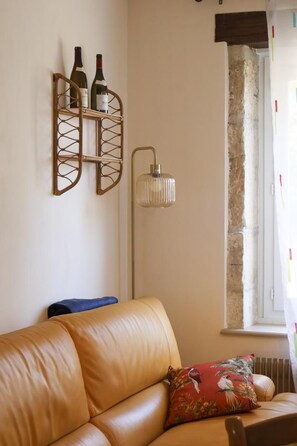Ein Wohnzimmer mit einer Ledersofa, einem Wandweinkühler und einer Stehlampe.