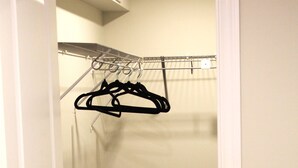 A closet with a hanging rod and a door.