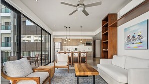 A modern living room with a sofa, chairs, a coffee table, and a dining area. - Villa Borghese Roma · Condo in Trendy Versailles (Puerto Vallarta)