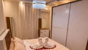 Ein Hotelzimmer mit Bett, einer Kandelaber, einem Schrank und einem gemusterten Teppich.