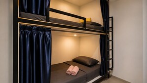 A bunk bed with a ladder, a single bed with a pillow, and a rolled towel on the lower bunk. - Nusantara Tajur Bogor Hostel By Reccoma (Bogor)