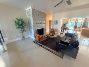 A living room with a fireplace, a sofa, a coffee table, and a TV.