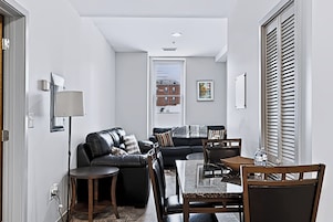 Una sala moderna con un sofá, una mesa de centro y un comedor con sillas.