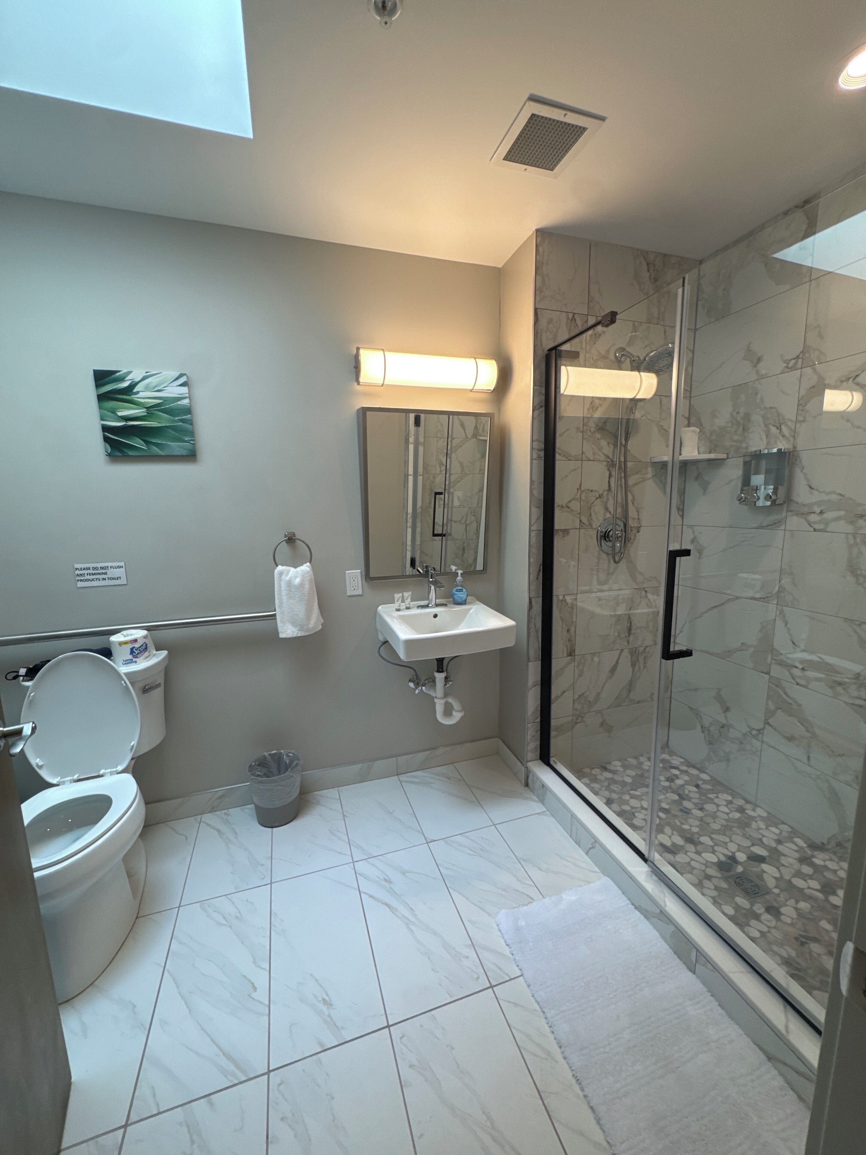 Ein modernes Badezimmer mit Toilette, Waschbecken und Dusche.