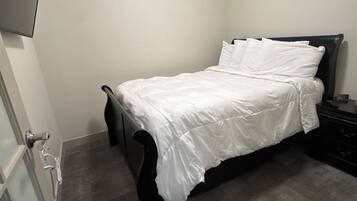 Een slaapkamer met een bed, een ladekast en een deur.