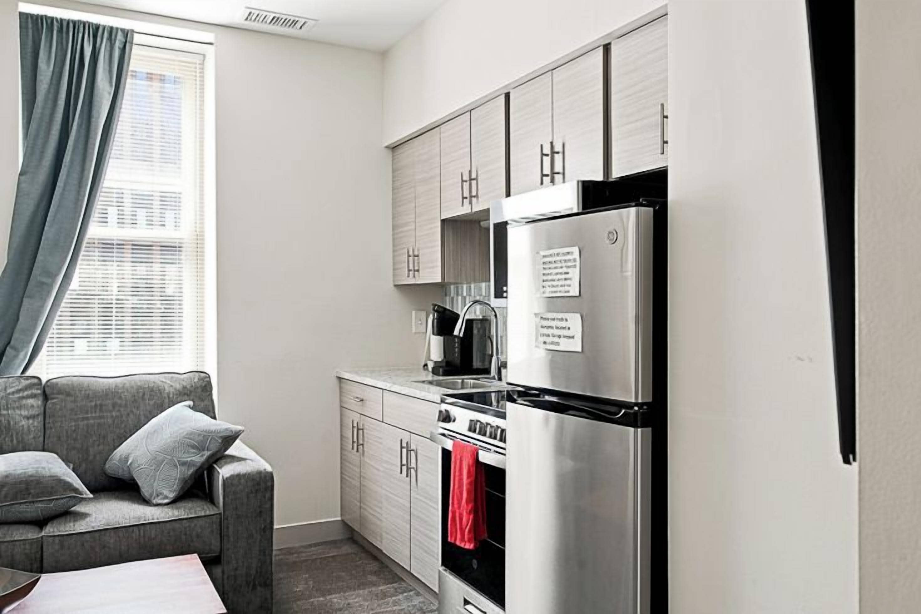 A compact kitchen with a refrigerator, oven, and cabinets.