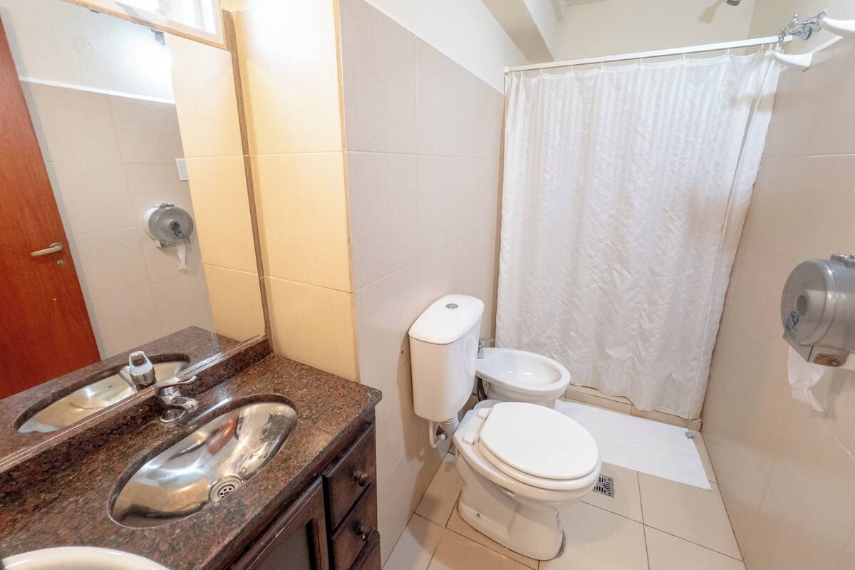Un baño con lavamanos, inodoro y ducha.