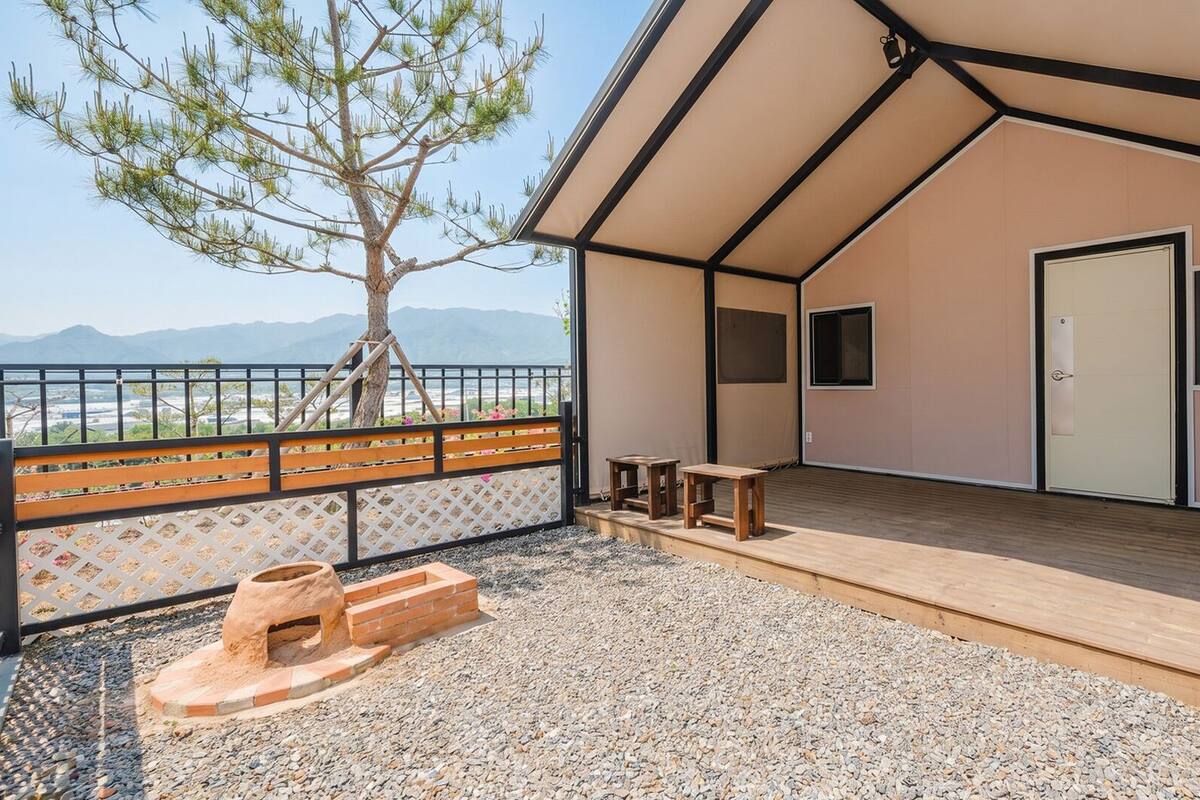 A modern building with a wooden deck, a small table, and a bench.