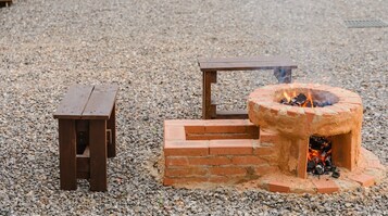 Una fogata con estructura de ladrillo y una mesa de madera.