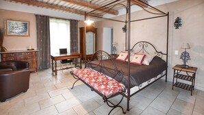 A bedroom with a four-poster bed, a desk, a chair, and a bedside table. - Maison avec piscine privée (Mazan)