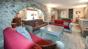 A cozy living room with stone walls, a pool table, and comfortable seating. - Maison avec piscine privée (Mazan)