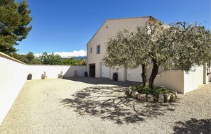 A building with a gravel courtyard, a tree, and a clear sky. - Gorgeous home in Villes- sur- Auzon with WiFi (Villes- sur- Auzon)