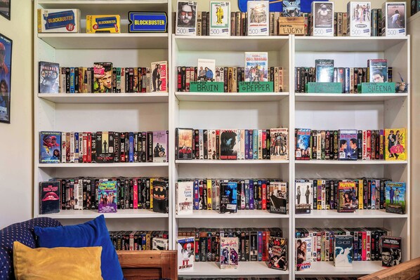 A bookshelf filled with various books and DVDs, including titles like 'Schreder' and 'The Shawshank Redemption.'