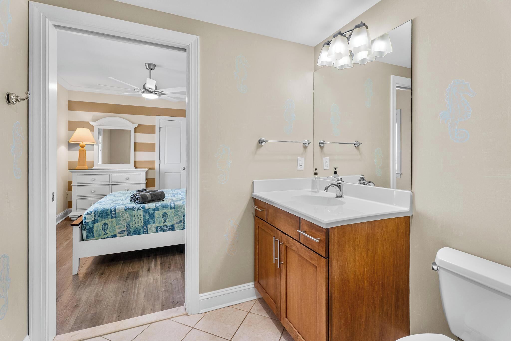 A bathroom with a wooden vanity, a white sink, and a mirror.
