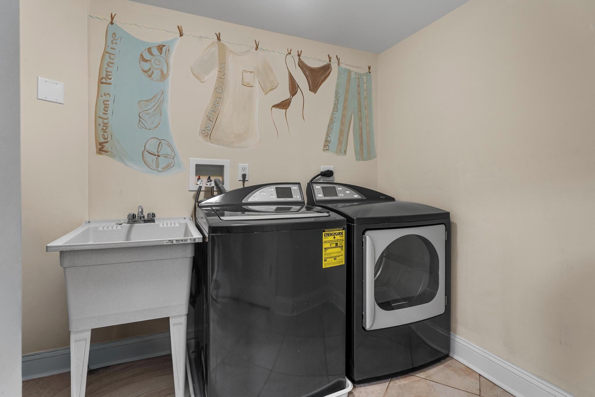 A laundry area with a washing machine, dryer, and sink.