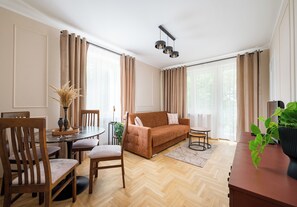 Ein modernes Wohnzimmer mit einer Couch, einem Esstisch, Stühlen und einem Couchtisch.