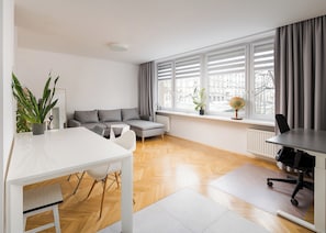 Ein modernes Wohnzimmer mit einem weißen Sofa, einem Esstisch und einem Globus auf einem Fensterbrett.