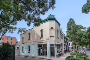 A corner building with a green roof, arched windows, and a sign reading 'NINSONS LANE.'