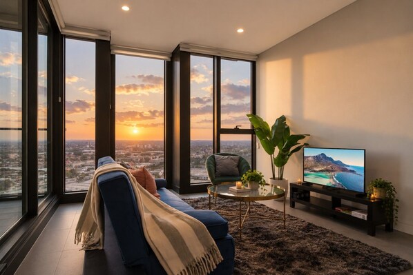 A modern living room with a sofa, a chair, a coffee table, and a television.