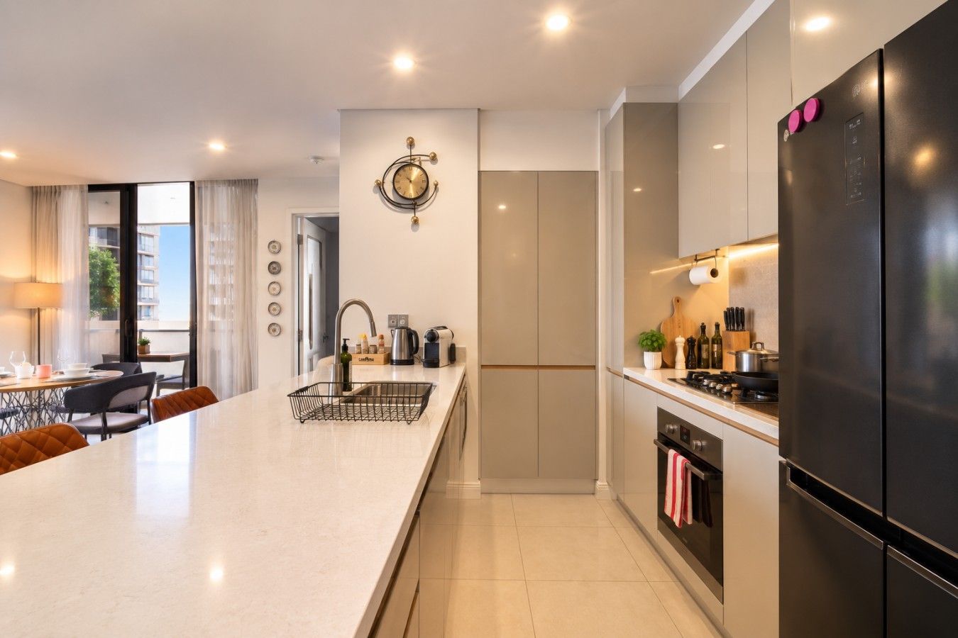 Una cocina moderna con una isla central, electrodomésticos de acero inoxidable y un comedor con vistas.