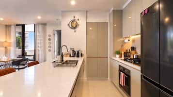 Una cocina moderna con una isla central, electrodomésticos de acero inoxidable y un comedor con vistas.