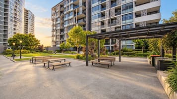 Un moderno complejo de apartamentos con varios edificios de gran altura, zonas de estar al aire libre y jardines bien cuidados.